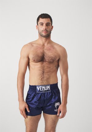 Temno modri satenski boksarski šorty z elastičnim pasom, ki na sprednji strani in ob strani ponuja bel logo "Venum" ter sijočo teksturo.