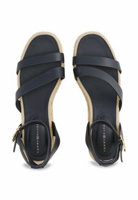 Sandali in pelle blu navy con cinghie incrociate, soletta imbottita e suola avvolta in juta. Presentano una cinghia posteriore con una fibbia color oro.