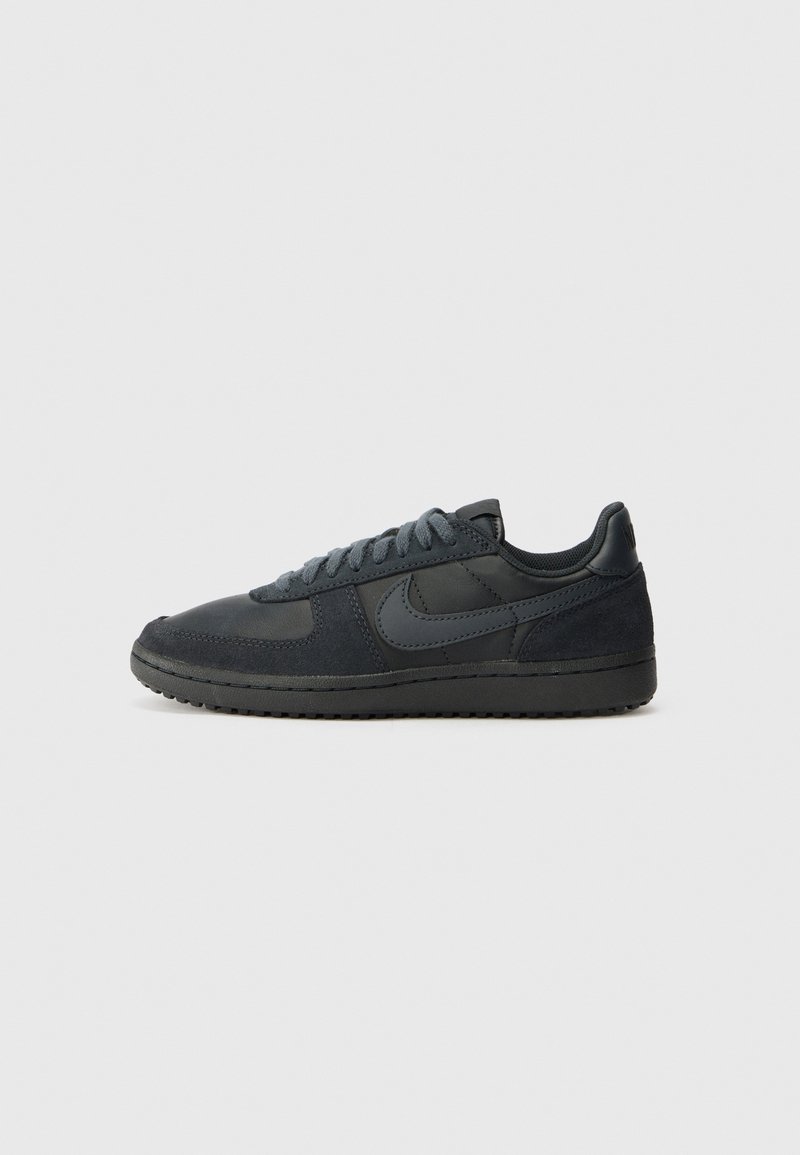 Baskets basses Nike noires avec panneaux en daim et cuir, semelle foncée et lacets noirs assortis, vues de l'intérieur.