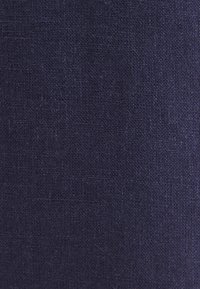 Tissu bleu marine foncé texturé avec un motif tissé visible et de légères variations de couleur.