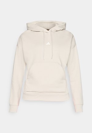 Lys beige hettegenser laget av myk stoff, med en frontlomme som en kenguru, hett med snøring, og liten hvit logo på brystet.