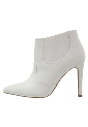Hvide læder ankelstøvler med spidse tæer, side-elastisk panel og høje stiletto hæle, der har en glat tekstur og strømlinet design.