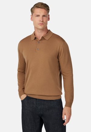 Camisa polo de manga larga marrón con cuello, tapeta de tres botones y puños acanalados. Textura suave y diseño ajustado. Llevada con pantalones oscuros.