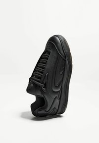 Schwarzer Sport sneaker mit einer strukturierten Lederoberfläche, auffälligen Schnürsenkeln und einer gepolsterten Sohle. Verfügt über ein schlankes Design und subtile Markenakzente.