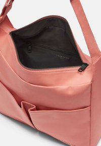 Różowa torba materiałowa z główną komorą na zamek błyskawiczny i czarnym wnętrzem. Posiada kieszeń zewnętrzną oraz gładki, zorganizowany design.