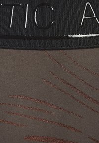 Black waistband with embossed text, paired with a brown fabric featuring shiny, copper-colored streaks in wave patterns.