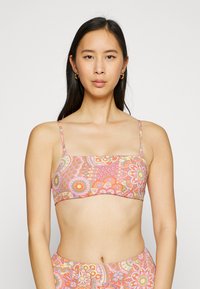 Viacfarebný bikiny top s kvetinovými a geometrickými vzormi, s tenkými nastaviteľnými ramienkami a obdlžníkovým tvarom. Vyrobený z hladkej tkaniny.