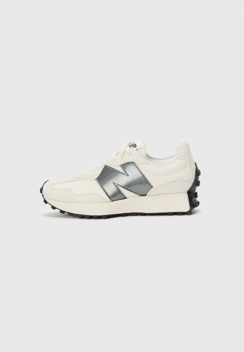 White sneaker with metallic silver accents, textured fabric, lightweight design, round toe, and black rubber outsole featuring spikes for grip.