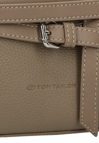 Sac à main en cuir texturé beige avec une boucle en métal argenté et des accents cousus. Présente le logo embossé "TOM TAILOR".