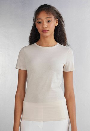 Beige short-sleeve t-shirt made of soft fabric, featuring a round neckline and a fitted design, smooth texture with minimal seams.