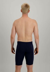 Shorts de bain bleu marine en tissu extensible, de longueur genou, avec une texture lisse et une taille élastique, montrés de dos.