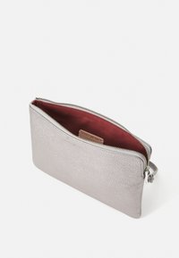 Metallic silver zippered clutch made of textured leather, featuring a deep red fabric interior and a small logo tag visible inside.
