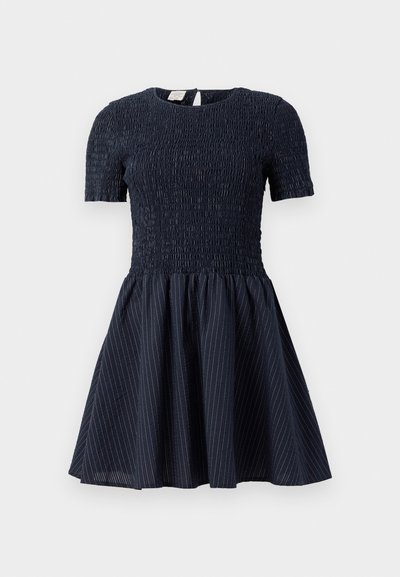 Tengerészkék, rövid ujjú ruha smockolt felsőrésszel, enyhén bővülő szoknyával, amelyen finom fehér csíkok találhatók, és hátul kulcslyuk kivágással.