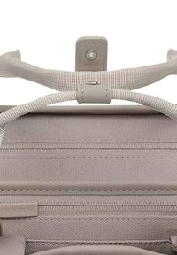 Beige stoffen tas met twee gevlochten handgrepen, vastgemaakt met een leren band met een metalen drukknoop, op een witte achtergrond.