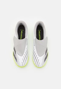 White and gray slip-on sports shoes with black digital patterns, neon yellow soles, and "PREDATOR" branding inside and on the sides.