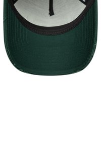 Casquette verte avec une visière noire et un tissu texturé. L'intérieur est de couleur gris clair et présente des coutures le long des bords.