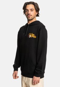 Sudadera con capucha negra y bolsillo frontal, con un colorido logo impreso y diseño de calavera. Tejido de textura fina con puños acanalados.
