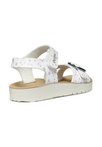Sandalo bianco con cinturini a motivo stellato, chiusura con velcro e una leggera soletta in sughero. Suola bianca testurizzata per una buona aderenza.