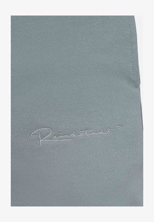 Hellgrauer Stoff mit einer strukturierten Oberfläche und einem gestickten Logo in hellerer Fadenfarbe. Das Design ist einfach und funktional.