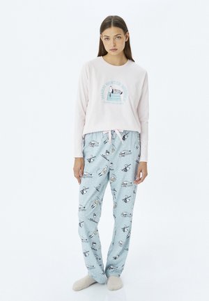 Haut à manches longues rose clair avec un graphique "Souhaits d'Hiver Chaleureux". Pantalons de pyjama bleus avec un motif de flocons de neige et des illustrations de personnages. Texture douce.