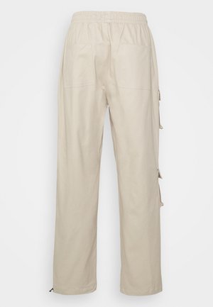 Beige recht gesneden broek met elastische tailleband en twee achterzakken, gezien van achteren tegen een witte achtergrond.