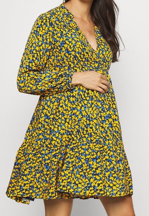Sukienka w kwiaty w kolorach niebieskim i żółtym, z głębokim dekoltem w serek, długimi rękawami oraz rozkloszowanym plisowanym dołem. Lekka tkanina o gładkiej fakturze.