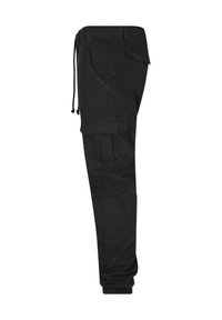 Pantalon cargo noir avec poignets élastiques, taille à cordon latéral et plusieurs poches à rabat le long de la jambe et des hanches.