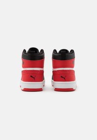 Tenisky s vysokým svrškem s červeným a černým designem, hladký syntetický materiál, bílá podrážka a kontrastní logo Puma na boku.
