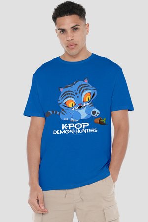 Young man wearing blue T-shirt with cartoon blue tiger playing with knocked-over plant pot and text "K-POP DEMON HUNTERS" in white.
