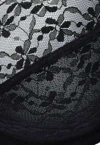 Black lace bralette with floral pattern, featuring a textured netting design and smooth underlay. Accented with delicate stitching details.