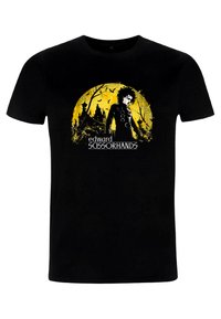 Černé bavlněné tričko s žlutým motivem Edwarda Scissorhandse, v pozadí siluety stromů a hradu, pod tím text.