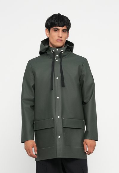 Manteau vert imperméable avec une capuche, doté de boutons-pression argentés, de deux poches avant et de cordons noirs. Texture lisse, semblable à du caoutchouc.