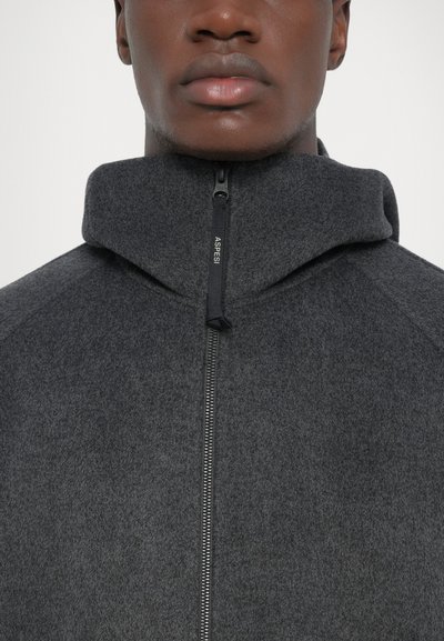 Gray fleece zip-up jacket with high collar, featuring a textured surface and a prominent zipper closure labeled "ASPSRI."