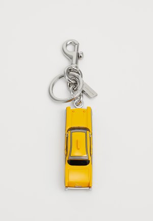 Portachiavi a forma di auto gialla con hardware argentato, tetto testurizzato, dettagli neri e un anello chiave attaccato. Design compatto e dettagliato.