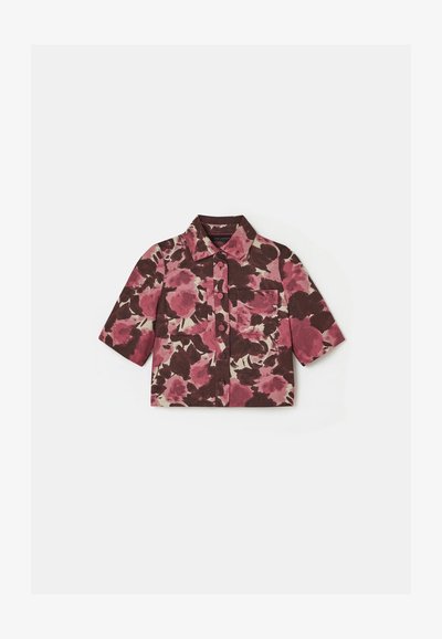 Korte mouwen overhemd in een roze en bruine bloemenprint, met een kraag, knoopsluiting aan de voorkant en twee borstzakken op een lichte achtergrond.