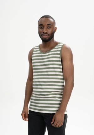 Green and white striped tank top, cotton material, scoop neckline, relaxed fit, worn with black pants. Plain background.