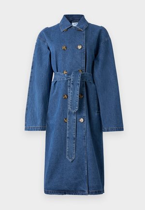Denim trench coat i en middels blå farge, har dobbeltknappede knapper, brede ermer, belte i midjen og rett snitt med sidelommer.
