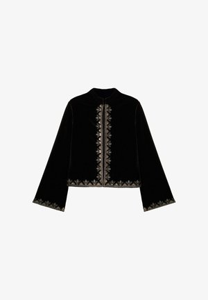 Chaqueta de terciopelo negro con cuello alto, mangas largas, decorada con bordados plateados a lo largo del frente y el dobladillo. Cierre central con cremallera.