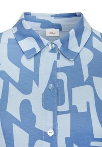 Svijetloplava bluzica s ovratnikom koja sadrži odvažan apstraktni uzorak u različitim nijansama plave, s blagom teksturom i prednjim kopčanjem na dugmad.