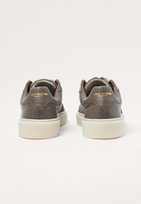 Bruine leren sneakers met suède accenten, crèmekleurige zool, gewatteerde kraag en gouden branding. Ontworpen met een lage silhouet.
