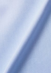 Ljusblått tyg med en slät textur och subtilt ribbat mönster. Materialet verkar lätt och andningsbart, hänger mjukt.