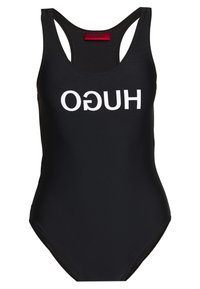 Bañador negro con escote en forma de barco y tirantes anchos. Presenta la llamativa letra blanca "HUGO" en el frontal. Textura suave, diseño clásico.