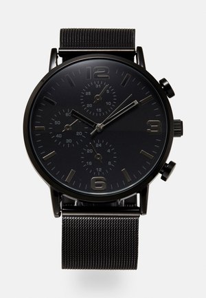 Montre chronographe noire avec bracelet en maille, trois sous-cadrans, index argentés et deux boutons-poussoirs sur le côté droit.