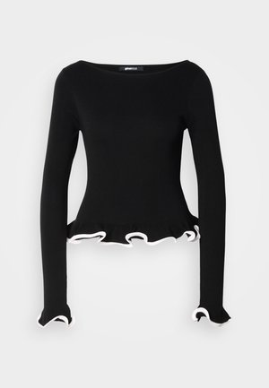 Crna bluzica dugih rukava s okruglim izrezom, s volanima na rubovima i manžetama obloženim bijelim. Izrađena od rebrastog pletenog materijala.