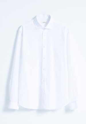 Camisa blanca de manga larga hecha de tejido ligero. Cuenta con un cuello clásico, puños de camisa, botones en la parte delantera y un sutil detalle de logo.