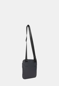 Borsa a spalla in pelle nera con texture liscia, forma rettangolare, tracolla regolabile e chiusura zip laterale per un facile accesso.