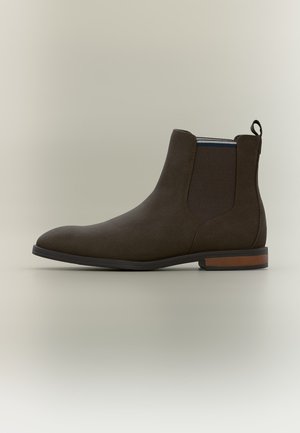 Dunkelbrauner Leder-Chelsea-Boot mit elastischen Seitenpaneelen, Zuglasche hinten und niedrigem gestapeltem Absatz mit schwarzer Sohle.