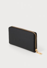 Carteira preta com fecho em zíper, feita de material suave, apresentando um zíper dourado e detalhes em metal. Forma retangular com linhas limpas.