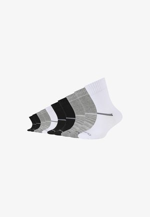 Ensemble de huit chaussettes de différentes couleurs : noir, gris et blanc. Chaque chaussette présente des textures variées et un détail de fines rayures horizontales.