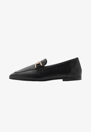 Mocassin plat en cuir noir avec bout pointu et détail de boucle en métal doré sur le dessus, talon bas et finition lisse.